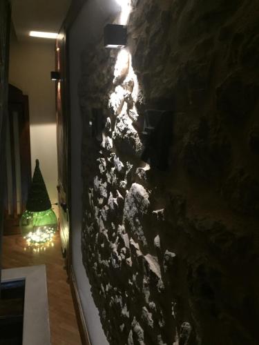 a rock wall with a christmas tree in a room at Il Peschio in Pescocostanzo