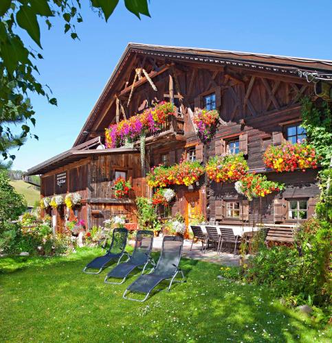 a group of chairs in front of a log house at Ferienhaus Knor in Umhausen