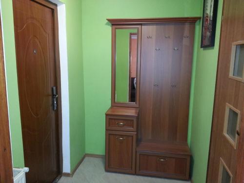 a closet with a wooden cabinet and a mirror at Pod Klonem in Lądek-Zdrój
