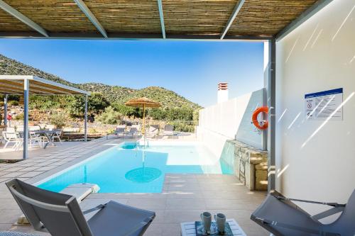 a swimming pool with two chairs and an umbrella at Summer Villas Crete in Balíon