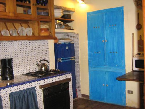 a kitchen with blue cabinets and a stove top oven at Casa Emilia in Stazzema
