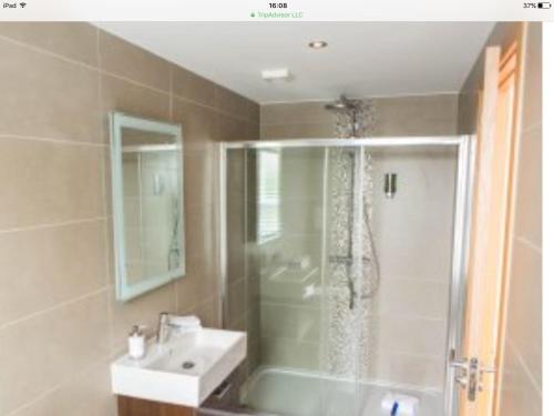 ein Bad mit einer Dusche und einem weißen Waschbecken in der Unterkunft The Townhouse in St Andrews