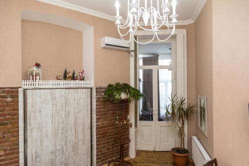 a hallway with a white door and a chandelier at Atlant Hotel in Tbilisi City