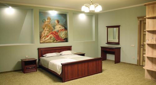 a bedroom with a bed and a painting on the wall at Veles Hotel in Dnipro