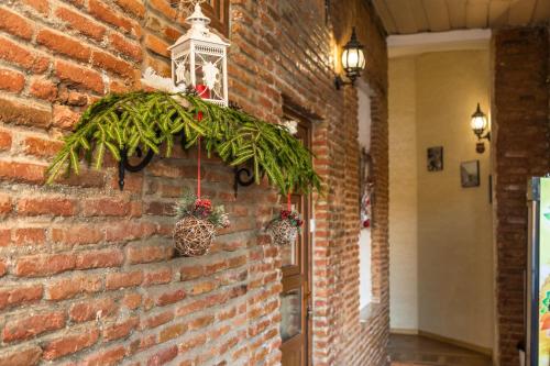 a brick wall with a wreath and potted plants on it at Atlant Hotel in Tbilisi City