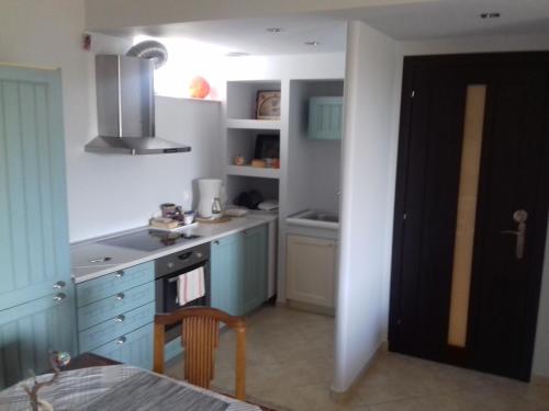 a kitchen with blue cabinets and a stove top oven at Blue Sky appartment in Pallini