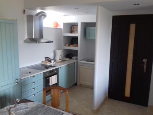 a kitchen with blue cabinets and a stove top oven at Blue Sky appartment in Pallíni