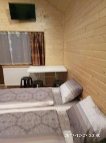 a bedroom with a bed in a wooden room at Turul in Berehove