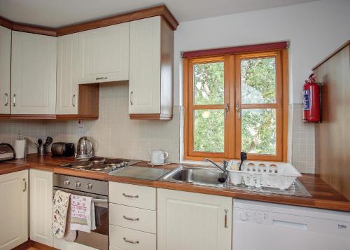 a kitchen with a sink and a window at Burren Court Lodge in Ballyvaughan