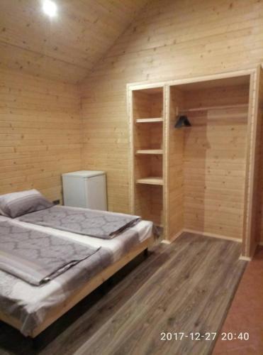 a bedroom with a bed and a wooden wall at Turul in Berehove
