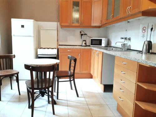 a kitchen with wooden cabinets and a table and chairs at Market Square Apartment II. in Budapest