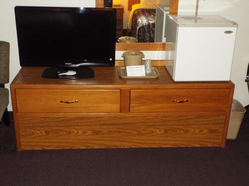 a wooden dresser with a television on top of it at FairBridge Inn & Suites Thorp in Thorp