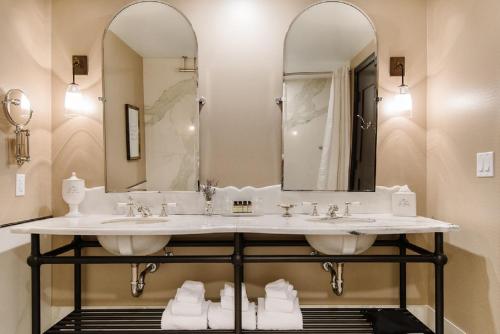 uma casa de banho com 2 lavatórios e um espelho grande em The Charmant Hotel em La Crosse