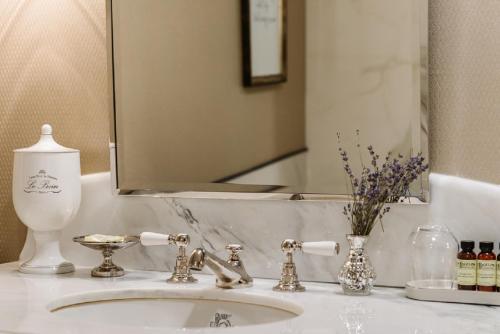 ラクロスにあるThe Charmant Hotelの洗面台と鏡を備えたバスルームのカウンター