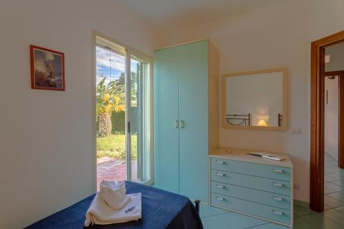 a bedroom with a blue dresser and a mirror at Case Spazioscena - Urania in Finale