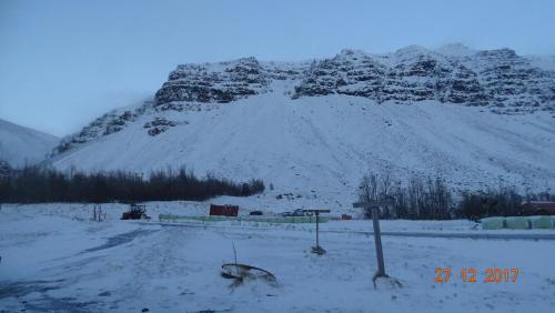 a snow covered mountain with a road in front of it at Miðjanes Reykhólahrepp in Reykhólar