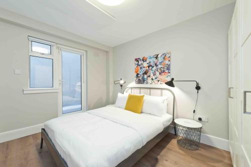 a white bedroom with a bed and a window at Temple Bar Crown Square Apartments in Dublin