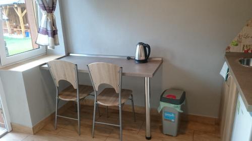 a tiny kitchen with a table and two chairs at Penzión VIAN in Krásnohorská Dlhá Lúka