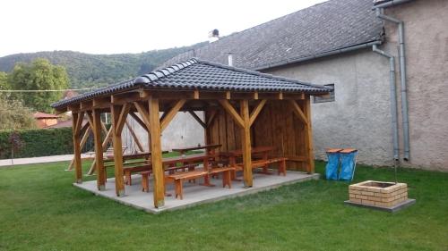 a wooden pavilion with a picnic table in a yard at Penzión VIAN in Krásnohorská Dlhá Lúka