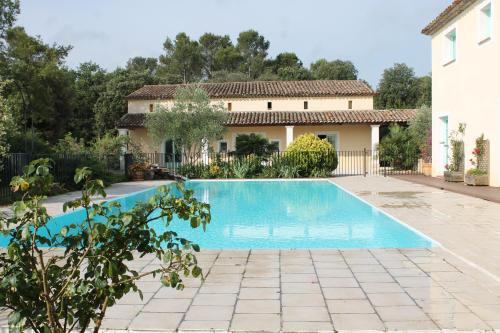 eine Villa mit einem Pool und einem Haus in der Unterkunft Entre Ciel et Terre in Besse-sur-Issole