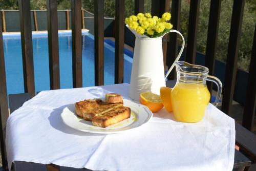 una mesa con un plato de comida y una jarra de jugo de naranja en Casa da Fraga, en Ferreira