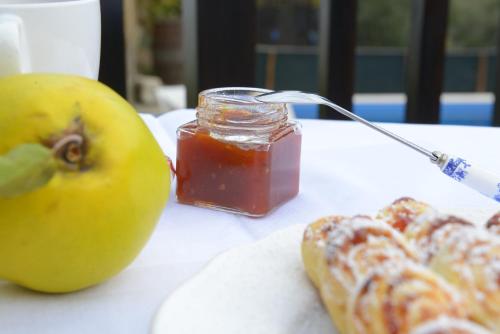 Una mesa con una manzana y un tarro de salsa. en Casa da Fraga, en Ferreira