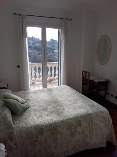een slaapkamer met een bed en een groot raam bij B&B Villa Isabella in Imperia