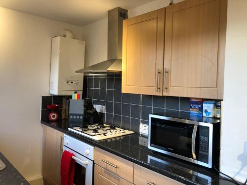 a kitchen with a microwave and a stove top oven at Wellesley Apartment in Leven-Fife