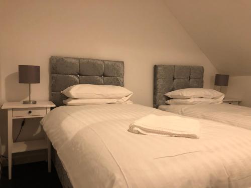 1 dormitorio con 2 camas y mesa con lámpara en Wellesley Apartment en Leven-Fife