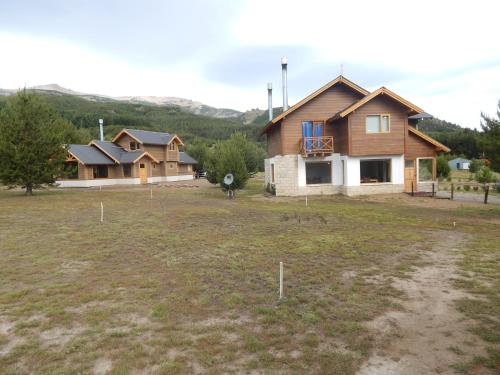 a house in the middle of a field with houses at Cabañas Wenuray in Villa Meliquina