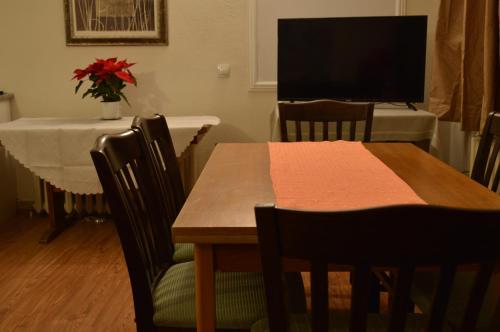 a dining room with a table and a television at Horizont Dobrinishte in Dobrinishte