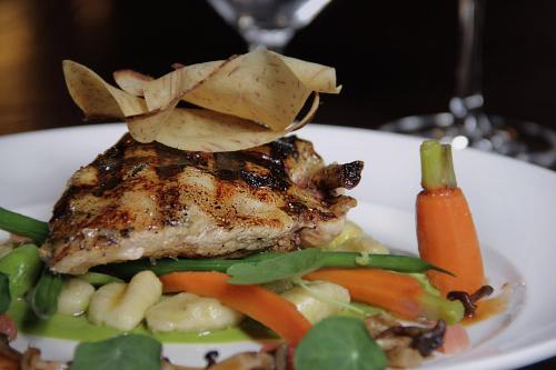 a plate of food with a piece of meat and vegetables at The Arrabelle at Vail Square, a RockResort in Vail