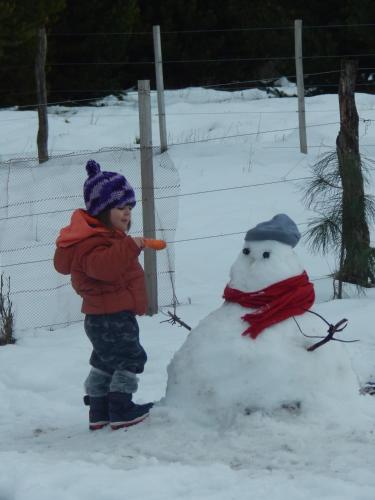 a young boy standing next to a snowman at Cabañas Wenuray in Villa Meliquina