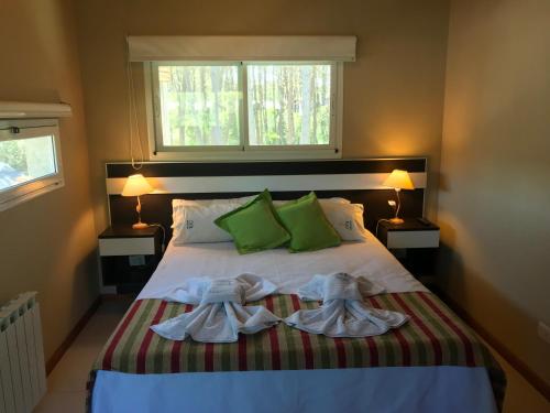 a bedroom with a bed with two robes on it at Complejo Pampa in Mar de las Pampas