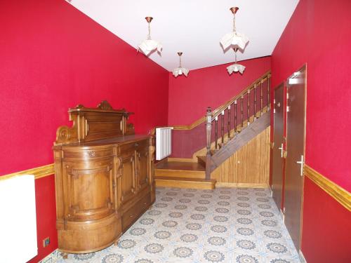 a room with red walls and a wooden staircase at Hôtel De Calais in Le Tréport