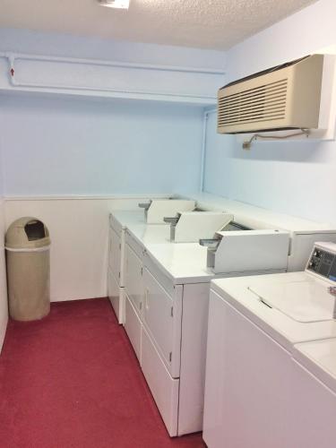 a laundry room with white cabinets and a air conditioner at Travel Inn & Suites in Atlanta