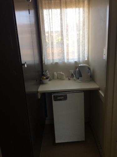 a small kitchen with a counter and a window at Yarram Commecial Hotel Motel in Yarram