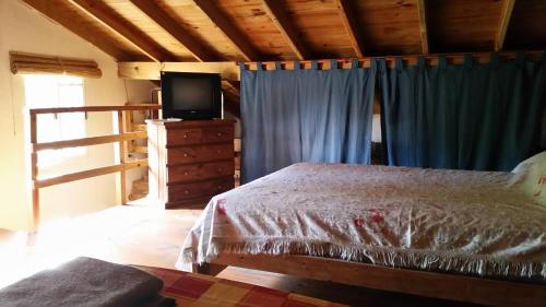 un dormitorio con cama y televisión en una habitación del Duplex Villa Gesell en Villa Gesell