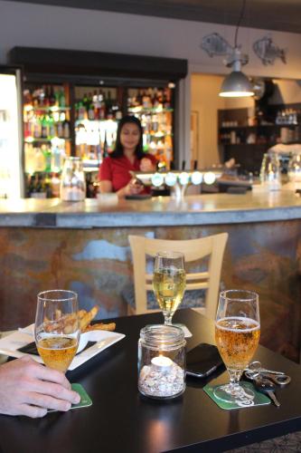 a couple of people sitting at a table with wine glasses at Beachcomber Lodge & Backpacker in Kaitaia
