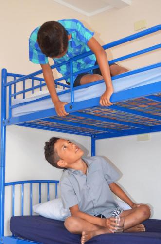two young boys sitting on bottom bunk beds at Beachcomber Lodge & Backpacker in Kaitaia