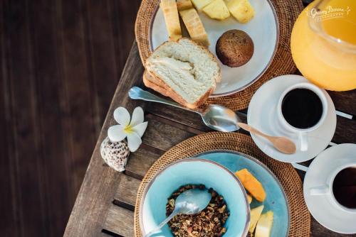 a table with plates of food and cups of coffee at Aore Island Resort in Luganville