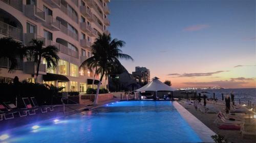 a swimming pool with a gazebo next to a building at Coral Princess Hotel & Dive Resort in Cozumel