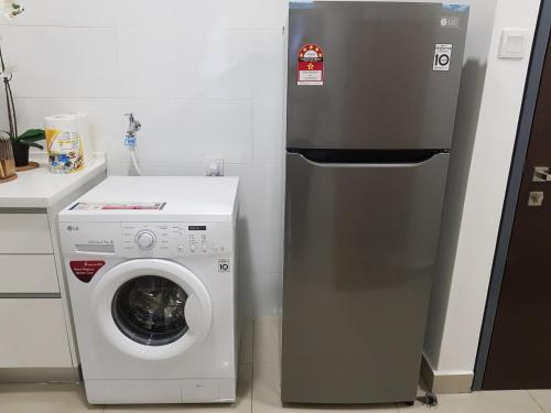 um frigorífico ao lado de uma máquina de lavar roupa na cozinha em Relaxing Studio@Cyber em Cyberjaya