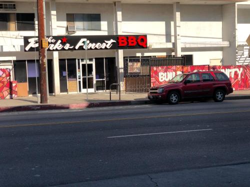 a red car parked in front of a building at Knights Inn Los Angeles Central / Convention Center Area in Los Angeles