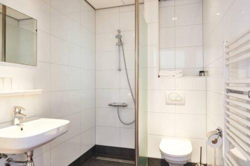 uma casa de banho branca com um lavatório e um WC em Stads Hotel Boerland em Emmen