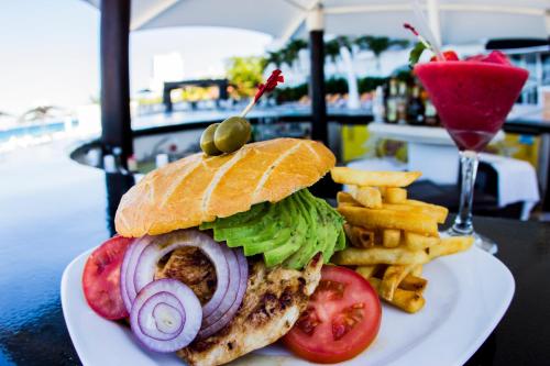 a sandwich and french fries on a white plate at Coral Princess Hotel & Dive Resort in Cozumel