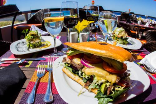 a sandwich on a plate on a table with wine glasses at Coral Princess Hotel & Dive Resort in Cozumel