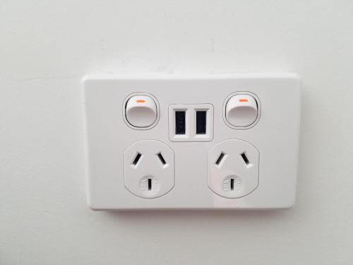a white switch on a wall with two arrows at New Smart Home Nearby Plaza in Auckland