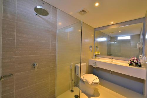 a bathroom with a shower and a toilet and a sink at Top Malioboro Hotel Jogja in Yogyakarta