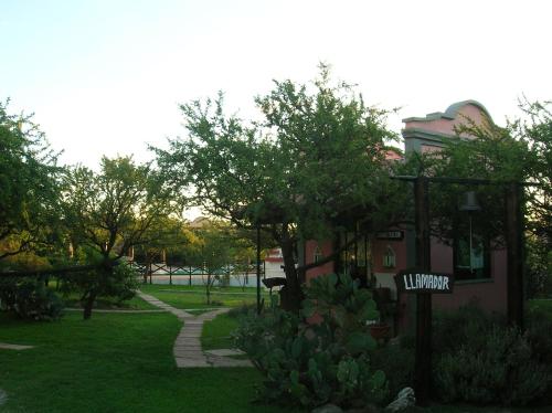 a house with a sign in a yard at Posada Los Antiguos-Adults Only in Merlo